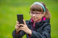 Close portrait Little girl with mobile phone. Little girl with standing and texting with the phone Royalty Free Stock Photo