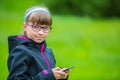 Close portrait Little girl with mobile phone. Little girl with standing and texting with the phone Royalty Free Stock Photo