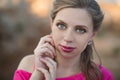 Close portrait of Pretty young blond lady woman with huge beautifull green eyes and pout red lips wearing dark pink dress.Make up