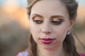 Close portrait of Pretty young blond lady woman with huge beautifull green eyes and pout red lips wearing dark pink dress.Make up