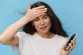 a close portrait of a sad, depressed woman with her hair blowing in the wind during a telephone conversation. Horizontal