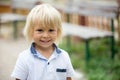 Close portrait of a smiling cute toddler child, beautiful blond boy, smiling at camera