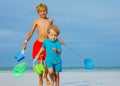 Close portrait of two boys on a beach with buckets and hoop-net Royalty Free Stock Photo