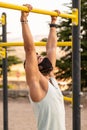 Strong young latin man doing calisthenics with mask