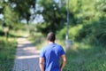 Close portrait of young man in blue t shirt standing outside in park with trees in background Royalty Free Stock Photo