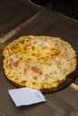 Close the round pizza on a wooden backing