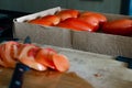 Close shoot of tomatoes in a box. Sliced tomatoes on a side
