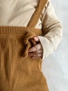 close shooting of a baby in a beige jacket and brown pants with suspenders. a small children's pen