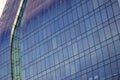 Close shot of a curved blue glass window wall of a modern and elegant corporative building. Royalty Free Stock Photo