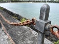 Close shot of a half new half rusty iron railing with seaside background.