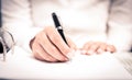 Close shot of a human hand writing something on the paper