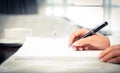 Close shot of a human hand writing something on the paper