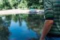 Close-shot of human hands holding a fishing-rod on the foreground.a man holds a fishing pole over the water, catches fish Royalty Free Stock Photo