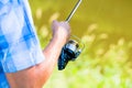 Close shot of sport fisherman reeling in line on fishing rod