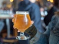 Close shot of a woman holding light beer snifter IPA