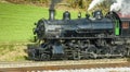 Close Side Aerial View of a Steam Engine Waiting, all Steamed Up, While it is Blowing Smoke