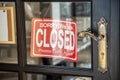 Close sign board hanging front of cafe mirror door. Business service and food drink concept.