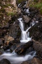 A close a small roadside waterfall as it tumbles on rocks on the dirt track road leading up to the Salmon Glacier, British Royalty Free Stock Photo