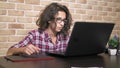 Close. teenager boy with curly brunette hair, in a plaid shirt works on a graphics tablet using a stylus