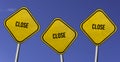 Close - three yellow signs with blue sky background