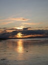 Evening sky with dark rainclouds and fiery sunlight reflections at Findhorn Bay, Scotland