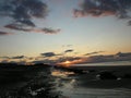 Evening sky with dark rainclouds and fiery sunlight reflections at Findhorn Bay, Scotland