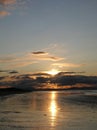 Evening sky with dark rainclouds and fiery sunlight reflections at Findhorn Bay, Scotland