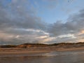 Evening sky with dark rainclouds and fiery sunlight reflections at Findhorn Bay, Scotland