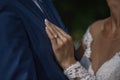 Close together bride and groom, bride holding left hand on groom`s chest in a gesture of love and commitment. Royalty Free Stock Photo