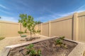 Close uo of growbeds at the backyard of a home with tree gravel and fence