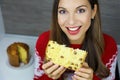 Close up from above of smiling young woman eating a slice of Panettone on Christmas time