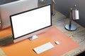 Close up and above view of designer office desk with white mock up computer display on wooden desk, rug, lamp and other items. Royalty Free Stock Photo
