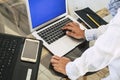 Close up and above view of woman hands typing on a keyboard and working with two laptop workstation computer at the office - Royalty Free Stock Photo