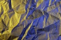 A close up abstract macro photo of crumpled creased paper lit with blue and orange flash gels Royalty Free Stock Photo