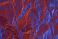 A close up abstract macro photo of crumpled creased paper lit with red and blue flash gels Royalty Free Stock Photo