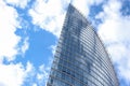 Close up abstract modern skyscraper architecture tall glass building with clouds in background Royalty Free Stock Photo