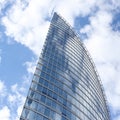 Close up abstract modern skyscraper architecture tall glass building with clouds in background Royalty Free Stock Photo