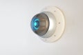 Close up of abstract round white cctv camera on concrete wall background. Safety system and security concept.