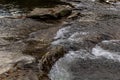 Close-up abstract texture above view of river torrent and clear fresh cold water flowing through mountain rocks in valley with Royalty Free Stock Photo