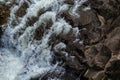 Close-up abstract texture above view of river torrent and clear fresh cold water flowing through mountain rocks in valley with Royalty Free Stock Photo