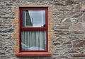 Close up abstract view of a red window surrounded by an antique stone brick wall texture Royalty Free Stock Photo