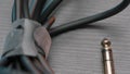 Close up of an acoustic cable lying on wooden table surface. Action. Rolled audio jack cable, details of professional Royalty Free Stock Photo