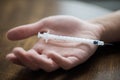 Close up of addict hand and used drug syringe