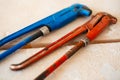 Close-up of adjustable gas wrenches of blue and red colour on wooden table Royalty Free Stock Photo