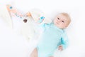 Close-up of adorable cute newborn baby girl of two months on white background. Lovely child playing with plush rabbit Royalty Free Stock Photo
