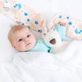 Close-up of adorable cute newborn baby girl of two months on white background. Lovely child playing with plush rabbit