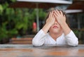 Close-up of adorable little Asian child girl expressed disappointment or displeasure on the wood table Royalty Free Stock Photo