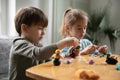 Close up little siblings playing with colorful play dough