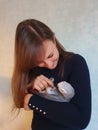 CLOSE UP: Adorable shot of a young woman cuddling with her friendly grey parrot. Royalty Free Stock Photo