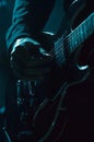 Close-up of adult caucasian male playing electric guitar in moody lighting